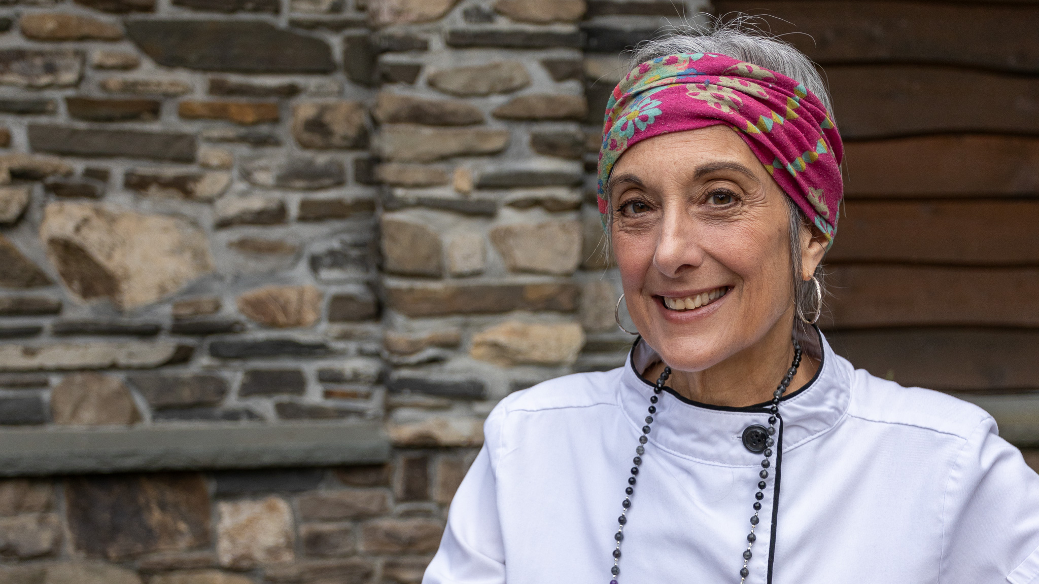 Cathy Vogt sitting at a table with a stone background