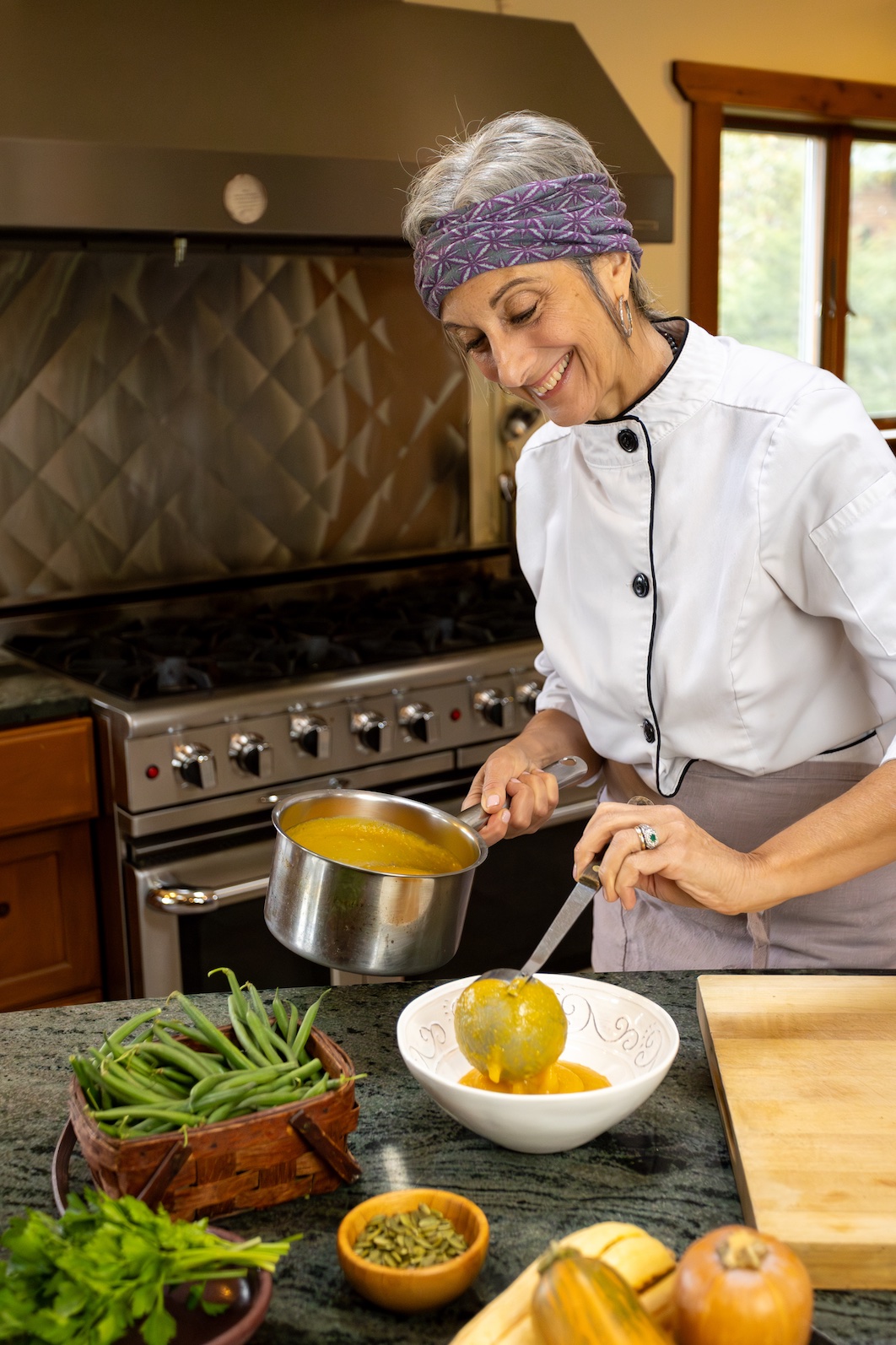 Cathy Vogt Private Chef Hudson Valley serving healthy soup in a bright kitchen